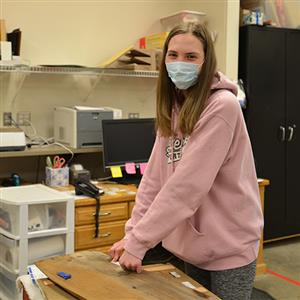 Hailee Sickmann placing a pricetag on a sign 